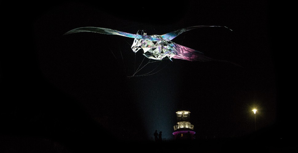 The Hatchling dragon transformed into a kite, flying above Smeaton's Tower on Plymouth Hoe